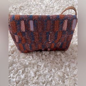 Textile purse with shoulder strap.